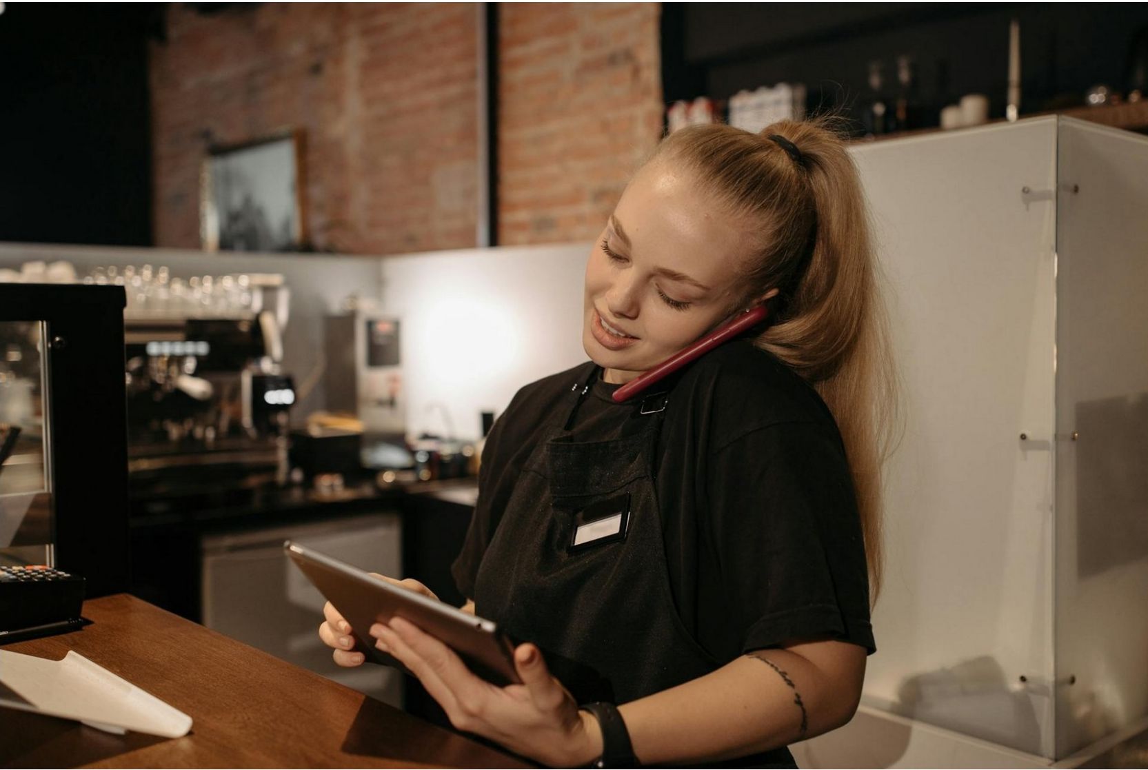 Small restaurant staff answering a missed call while managing the counter during a busy dinner service.